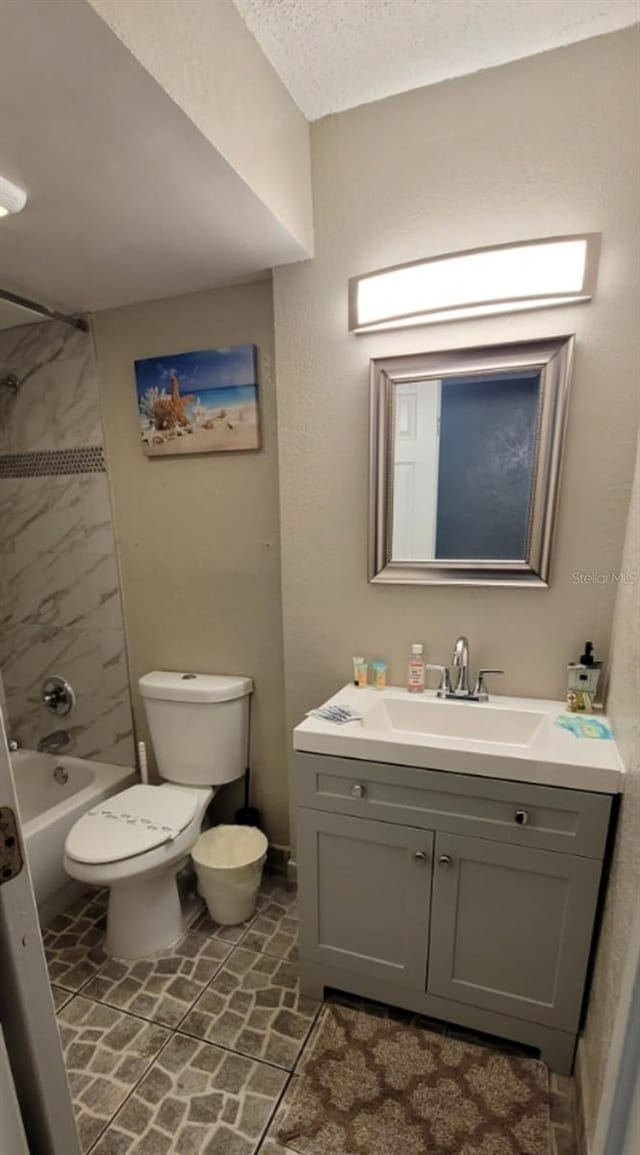 full bathroom with toilet, tile patterned floors, vanity, and tiled shower / bath