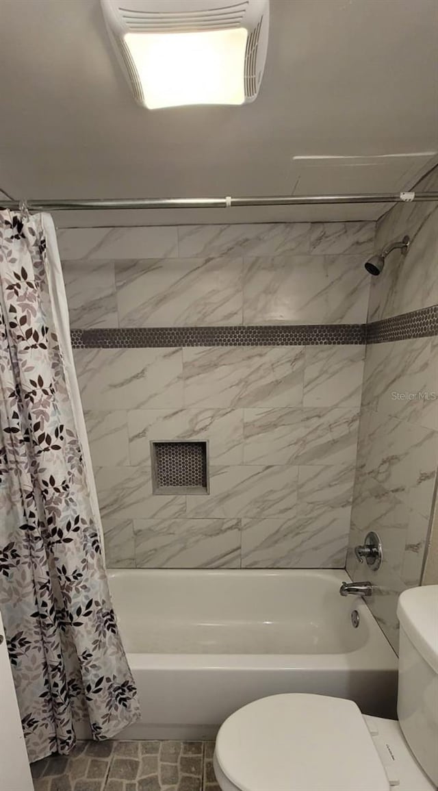 bathroom with shower / bathtub combination with curtain and toilet