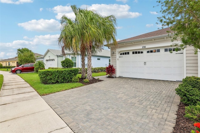 view of front of home with a garage and decorative driveway