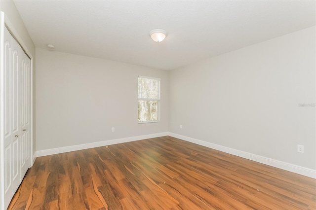 unfurnished bedroom with hardwood / wood-style flooring and a closet