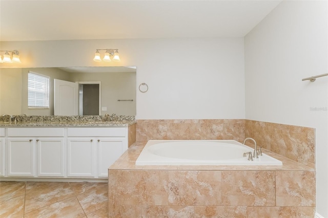 bathroom with vanity, tiled tub, and tile patterned flooring