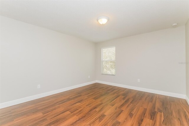 empty room with hardwood / wood-style flooring