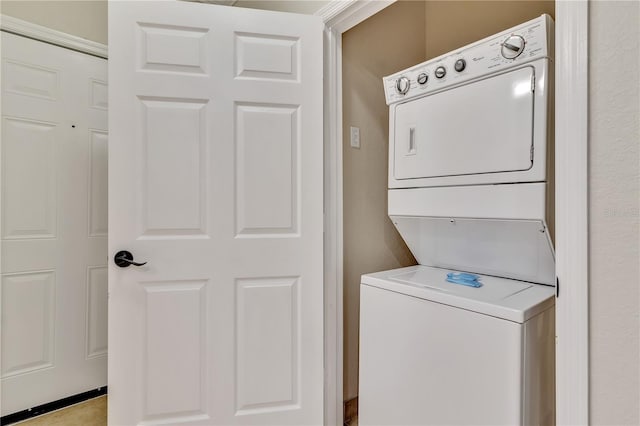 clothes washing area featuring stacked washing maching and dryer