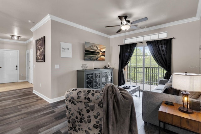 living area with ceiling fan, crown molding, baseboards, and wood finished floors