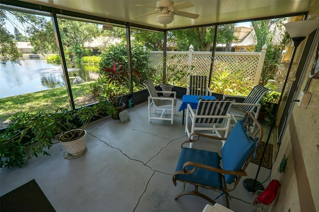 unfurnished sunroom with a water view and ceiling fan