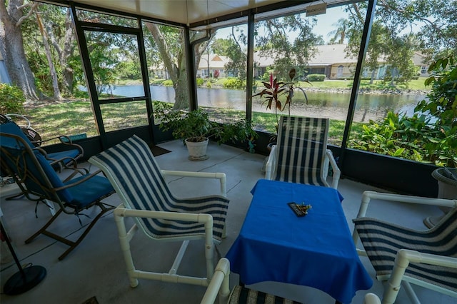 sunroom / solarium featuring a water view