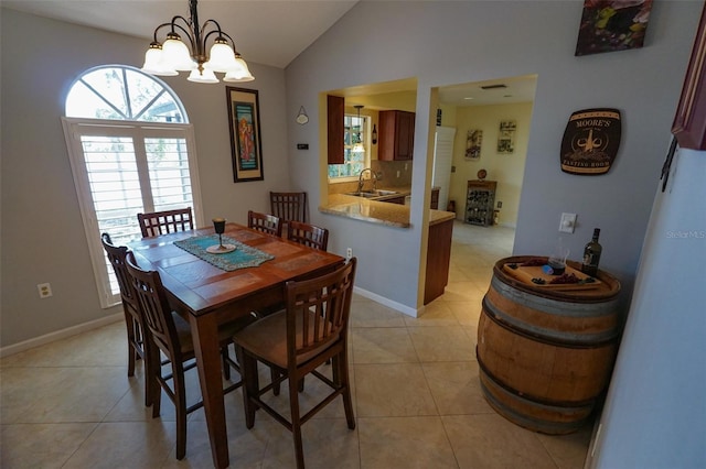 dining space featuring light tile patterned flooring, vaulted ceiling, sink, and a chandelier