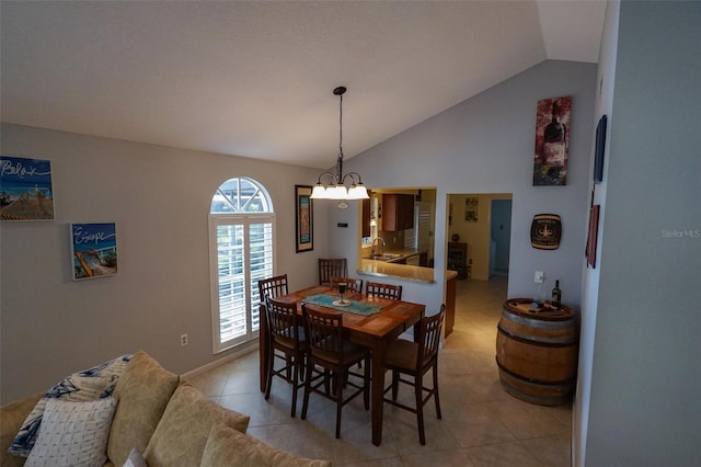 dining space featuring light tile patterned flooring, vaulted ceiling, a notable chandelier, and sink