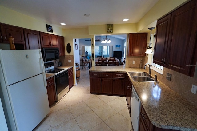 kitchen with a wealth of natural light, sink, pendant lighting, and white appliances