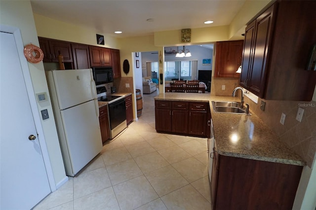 kitchen with white appliances, backsplash, sink, decorative light fixtures, and a chandelier