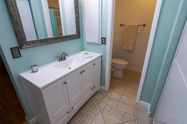 bathroom featuring tile patterned flooring, vanity, and toilet