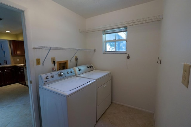 laundry area with washer and clothes dryer and light tile patterned flooring