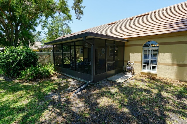 back of house featuring a sunroom and a yard