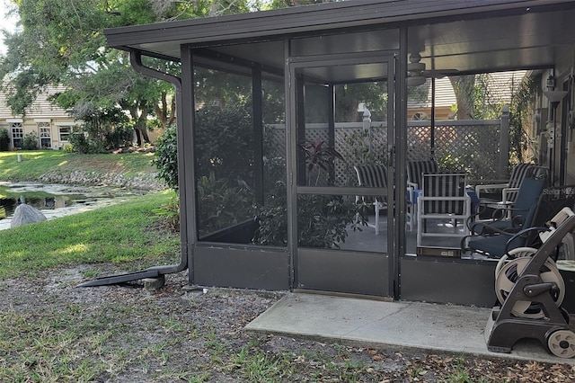 view of gate with a yard and ceiling fan