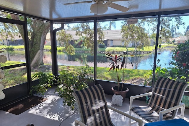 sunroom / solarium featuring ceiling fan and a water view