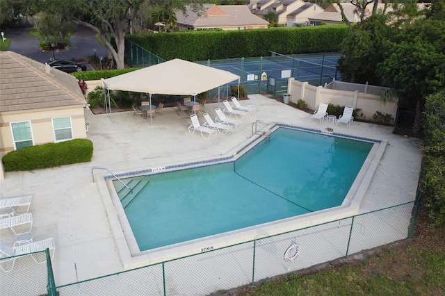 view of swimming pool with tennis court