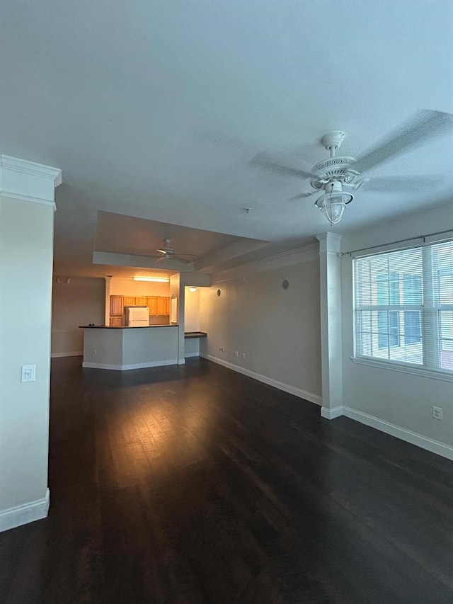 unfurnished living room with dark hardwood / wood-style floors and ceiling fan