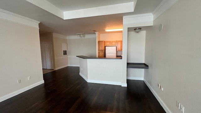 kitchen with dark hardwood / wood-style flooring, kitchen peninsula, white fridge, light brown cabinetry, and ornamental molding