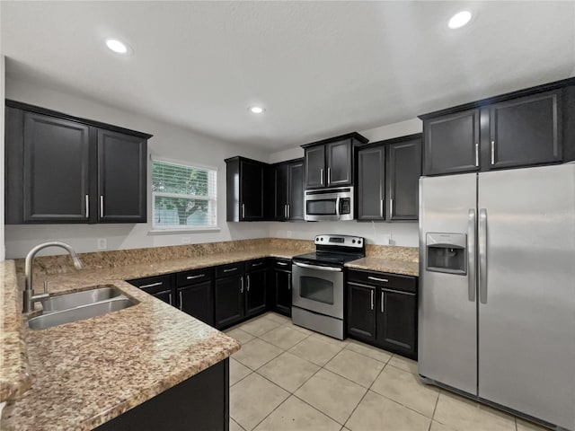 kitchen with light stone countertops, sink, stainless steel appliances, and light tile patterned floors