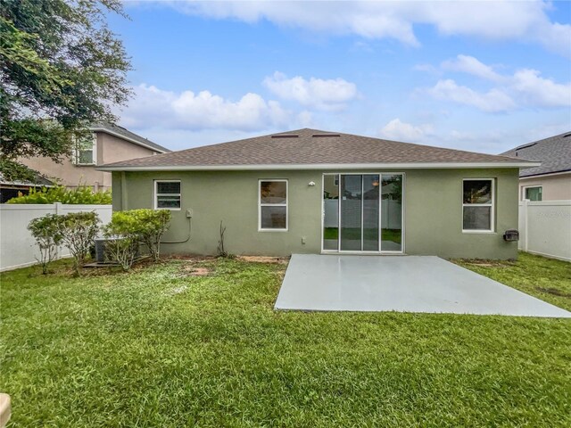 back of property featuring a lawn and a patio