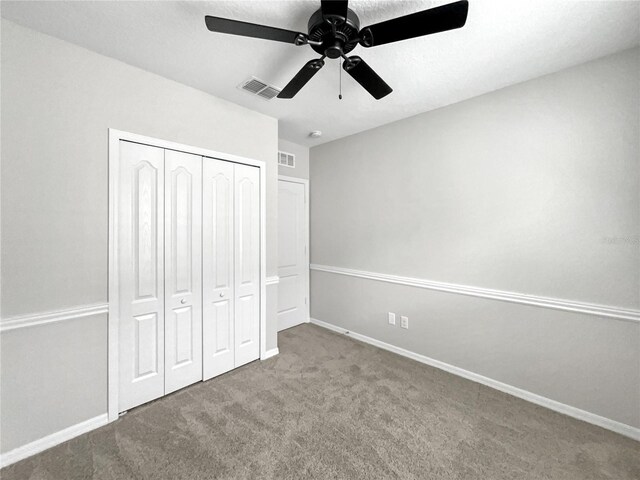 unfurnished bedroom with ceiling fan, a closet, and carpet