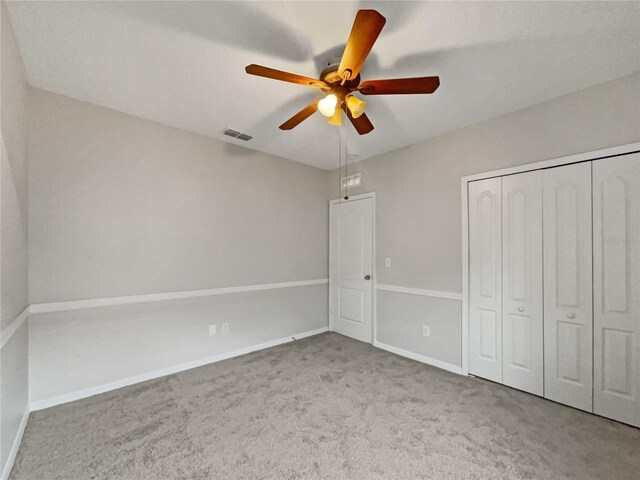 unfurnished bedroom with ceiling fan, carpet flooring, and a closet