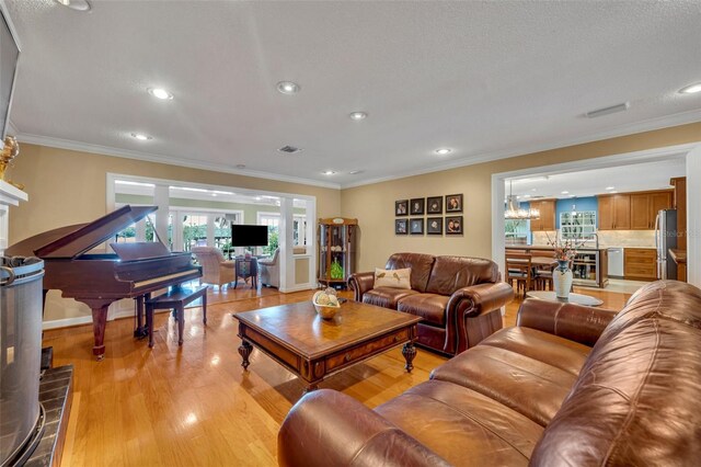 living room with light wood-type flooring, crown molding, beverage cooler, and a brick fireplace