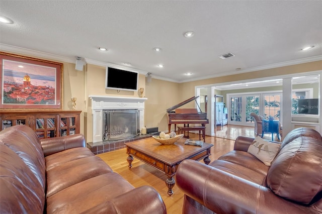 279 Rippling Ln, Winter Park, FL 32789 - living area with crown molding, light wood-type flooring, a tiled fireplace, recessed lighting, and a textured ceiling