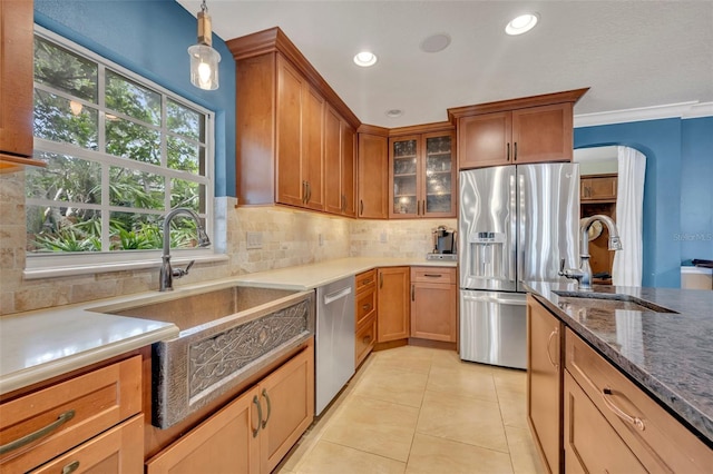 kitchen with tasteful backsplash, ornamental molding, stainless steel appliances, sink, and hanging light fixtures