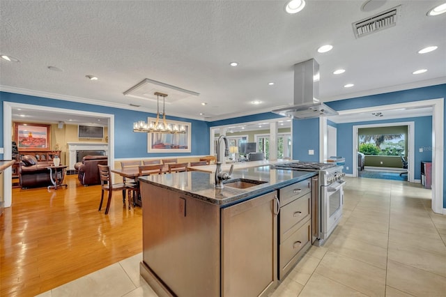 279 Rippling Ln, Winter Park, FL 32789 - kitchen featuring high end range, a sink, crown molding, island exhaust hood, and a center island with sink