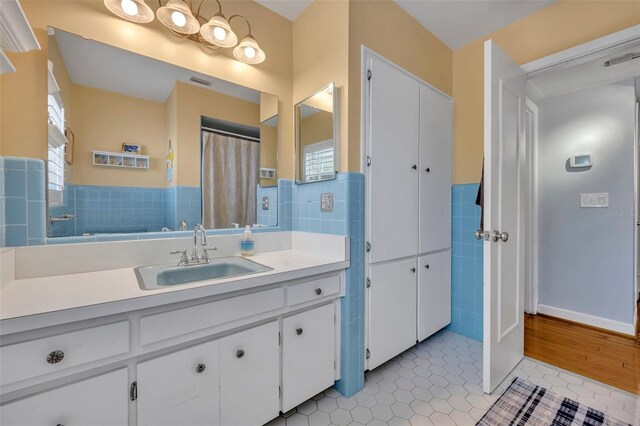 bathroom with vanity, tile patterned floors, and tile walls