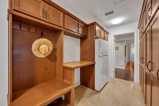 mudroom featuring light tile patterned floors and a textured ceiling