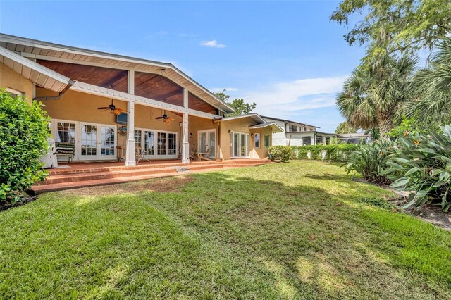 rear view of property with french doors, a yard, and ceiling fan