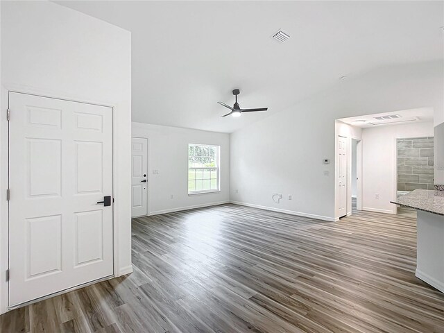 unfurnished living room featuring ceiling fan and dark hardwood / wood-style floors