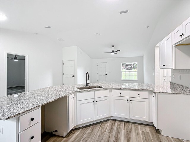 kitchen with sink, kitchen peninsula, ceiling fan, and white cabinetry