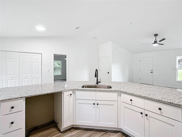 kitchen featuring sink, white cabinetry, ceiling fan, light wood-type flooring, and light stone countertops