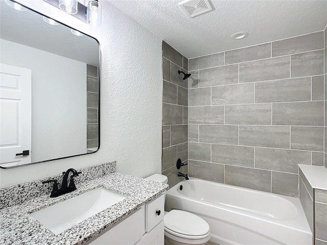 full bathroom with toilet, vanity, a textured ceiling, and tiled shower / bath combo