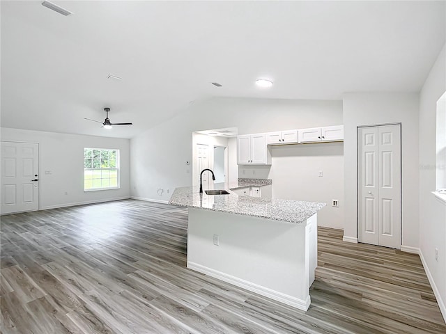 kitchen featuring ceiling fan, light stone counters, hardwood / wood-style flooring, sink, and white cabinetry