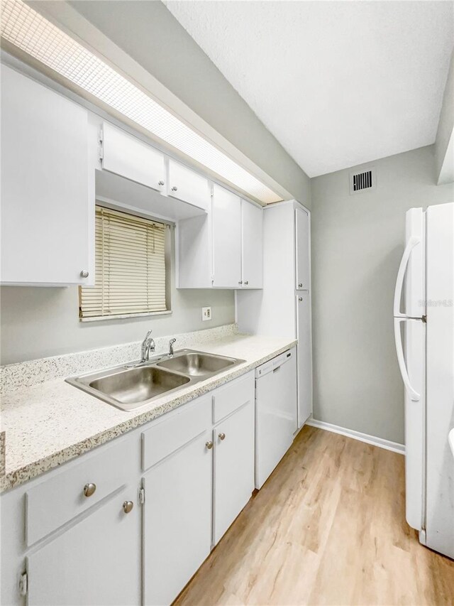 kitchen with light wood-type flooring, sink, white appliances, and white cabinetry