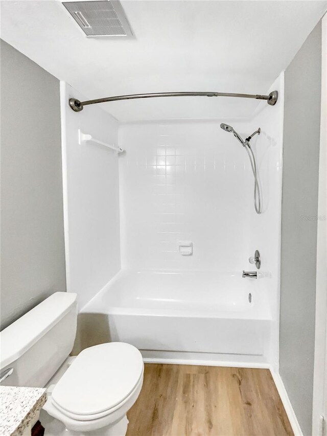 full bathroom with shower / tub combination, vanity, toilet, and hardwood / wood-style floors