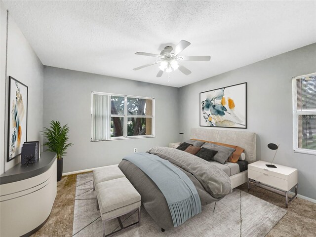 bedroom with ceiling fan and a textured ceiling