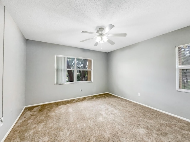 empty room featuring a textured ceiling, ceiling fan, and carpet floors