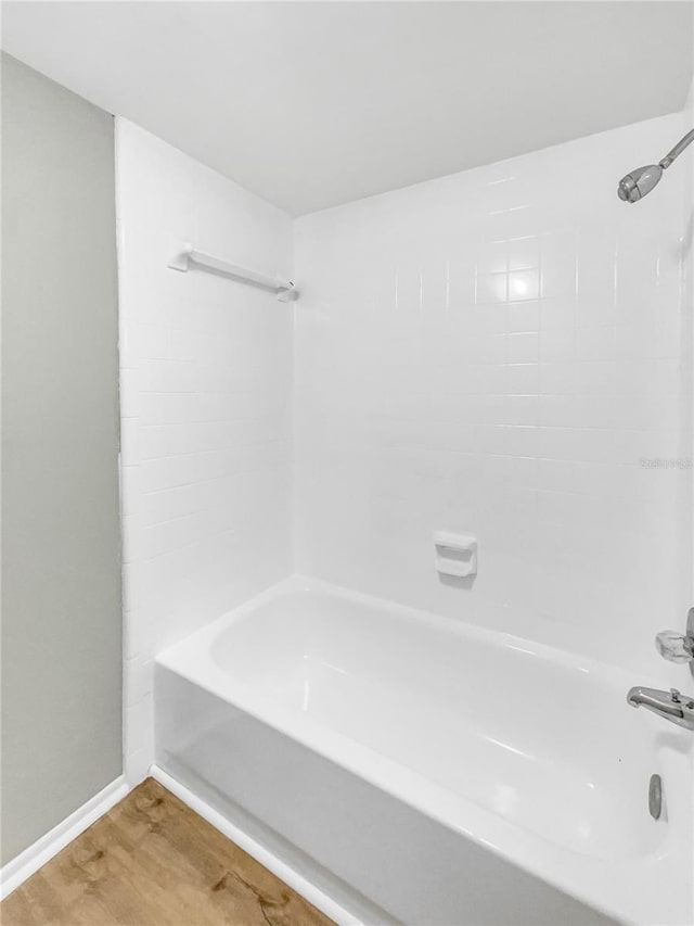 bathroom with hardwood / wood-style floors and shower / bathtub combination