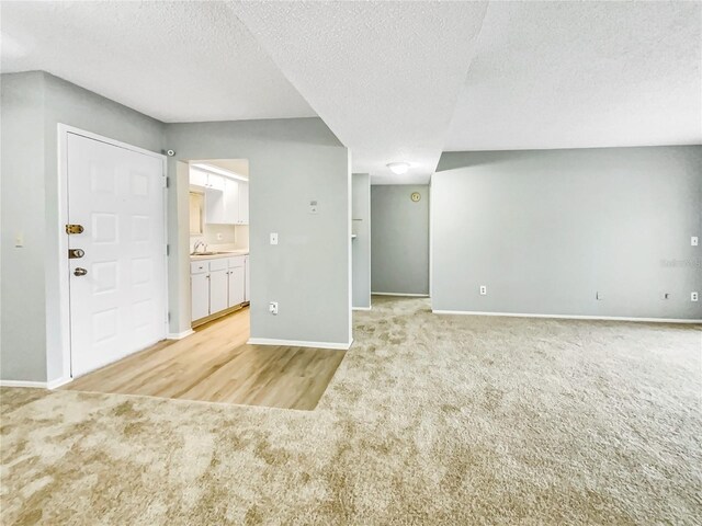 interior space with a textured ceiling and sink