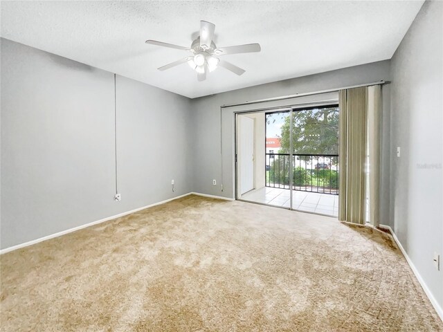 carpeted empty room with ceiling fan and a textured ceiling