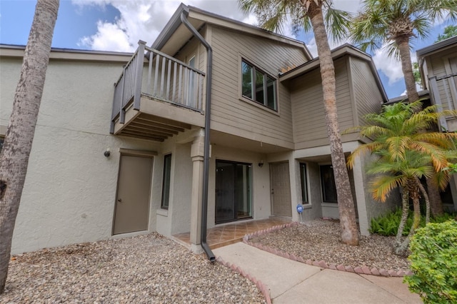 view of front of house with a balcony and stucco siding