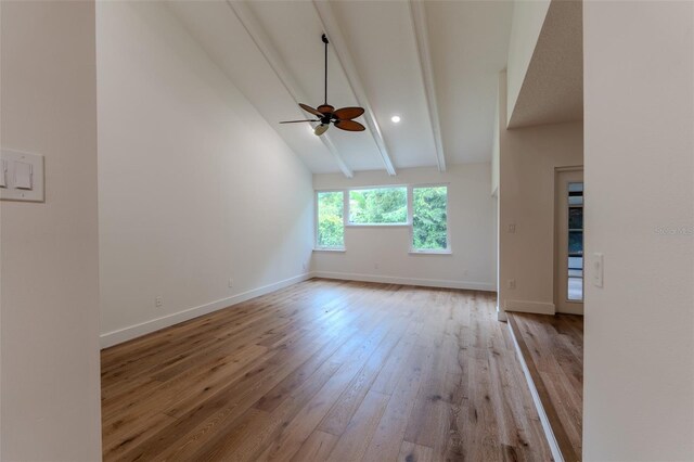 empty room with hardwood / wood-style flooring, high vaulted ceiling, beamed ceiling, and ceiling fan