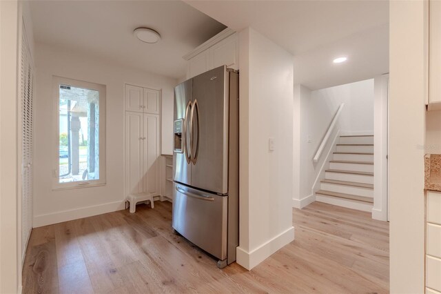 kitchen with white cabinetry, stainless steel fridge, and light hardwood / wood-style flooring