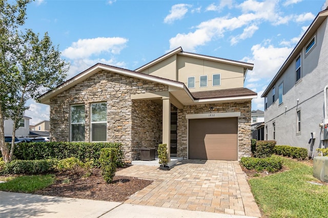 view of front of property featuring a garage and central AC unit