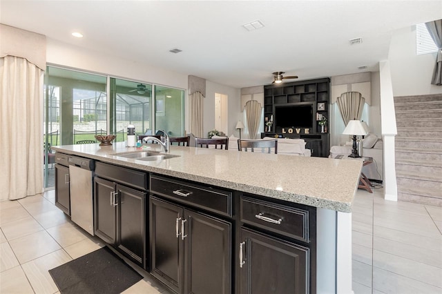 kitchen featuring light tile patterned floors, an island with sink, ceiling fan, sink, and stainless steel dishwasher